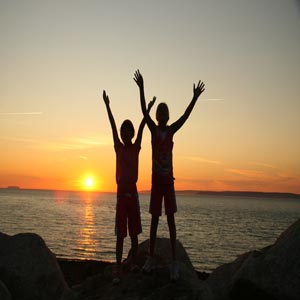 دو کودک دست ها را به آسمان برده در حال دعا کردن
