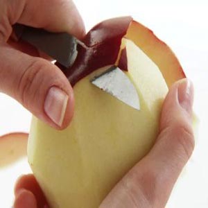 دست ها در حال سیب پوست کندن با چاقو