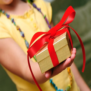 دختر خردسال در حال هدیه دادن یک جعبه طلایی با روبان قرمز