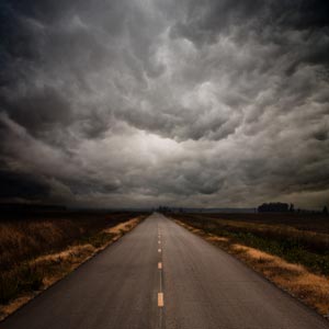 جاده ای منتهی به افق در هوای ابری و طوفانی