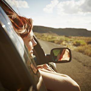 زن سوار بر ماشین با سر بیرون از شیشه
