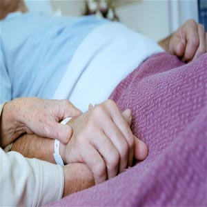 پیرمرد و پیرزنی در بیمارستان دست در دست یکدیگر